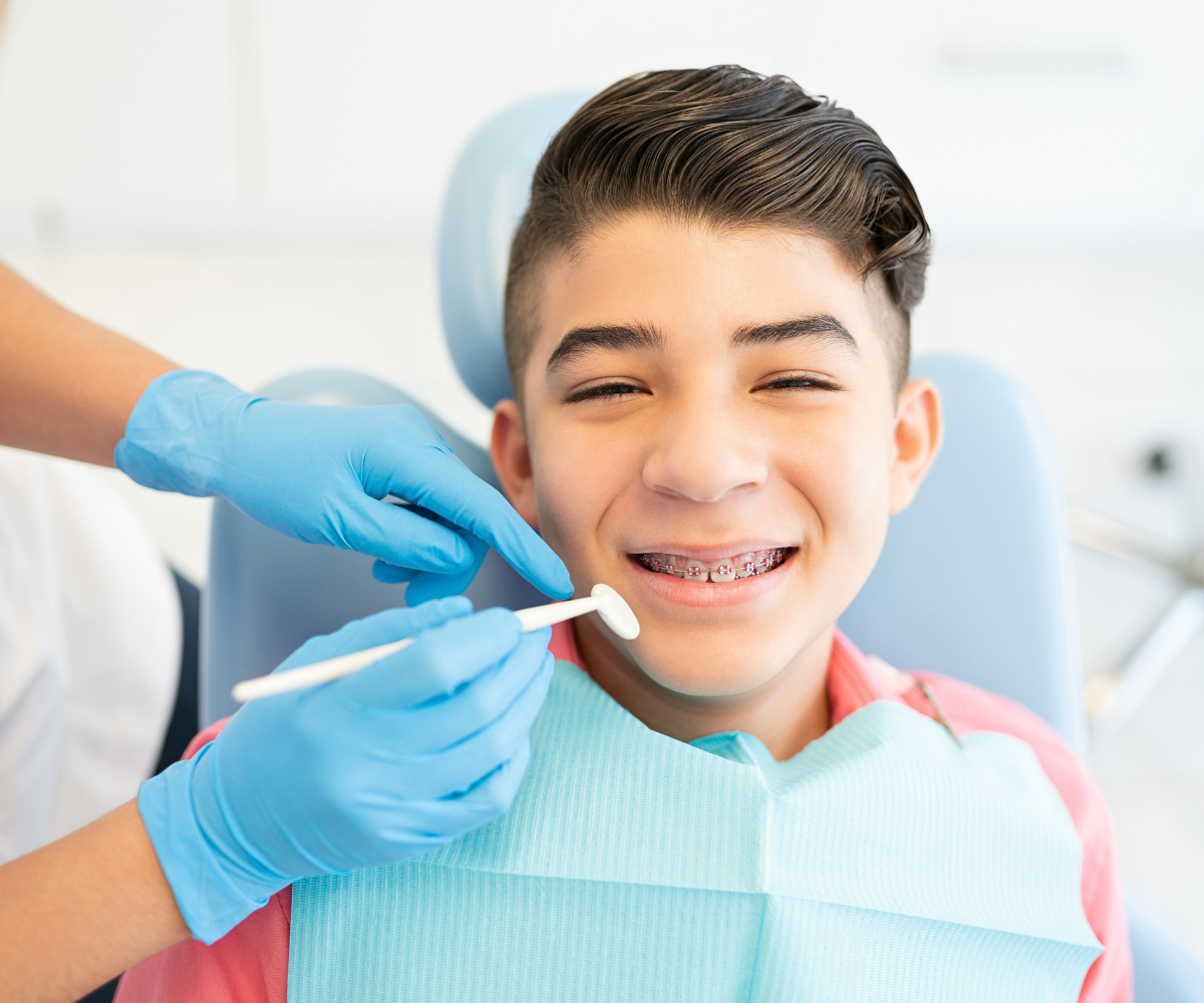 teen boy smiling with metal braces on at an aubrey barrett orthodontics location