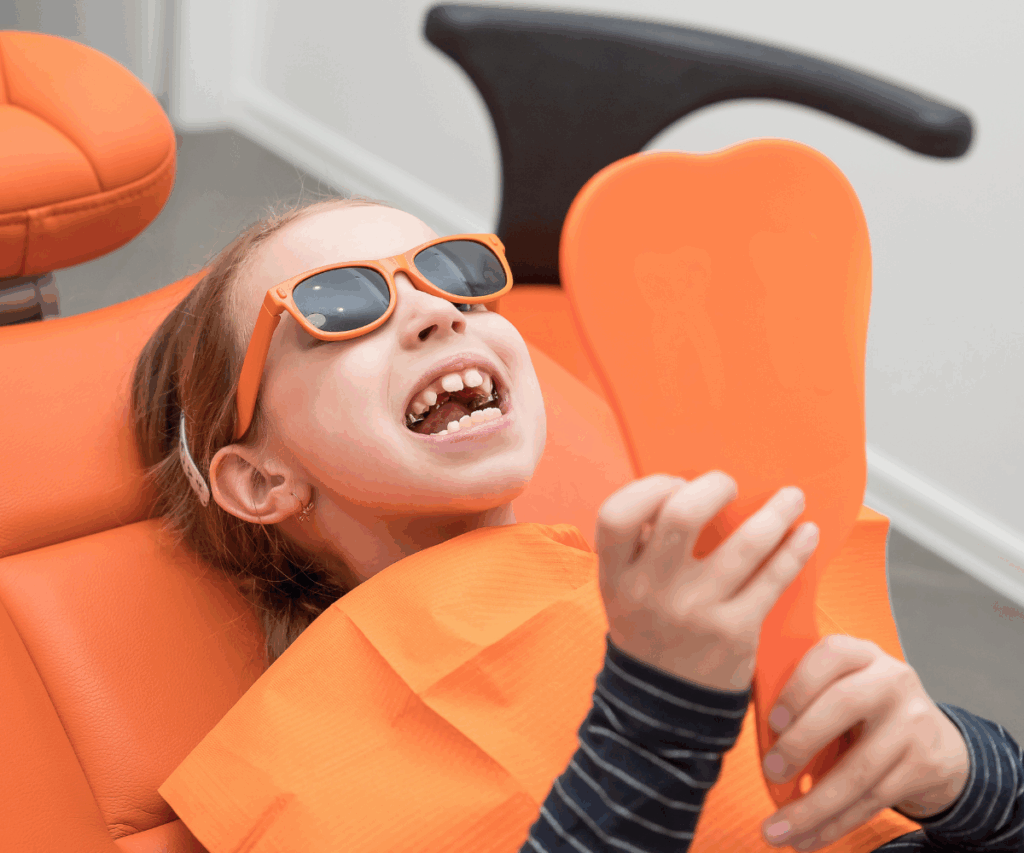 girl looking at inserted palatal expander in mirror in her orthodontists office california