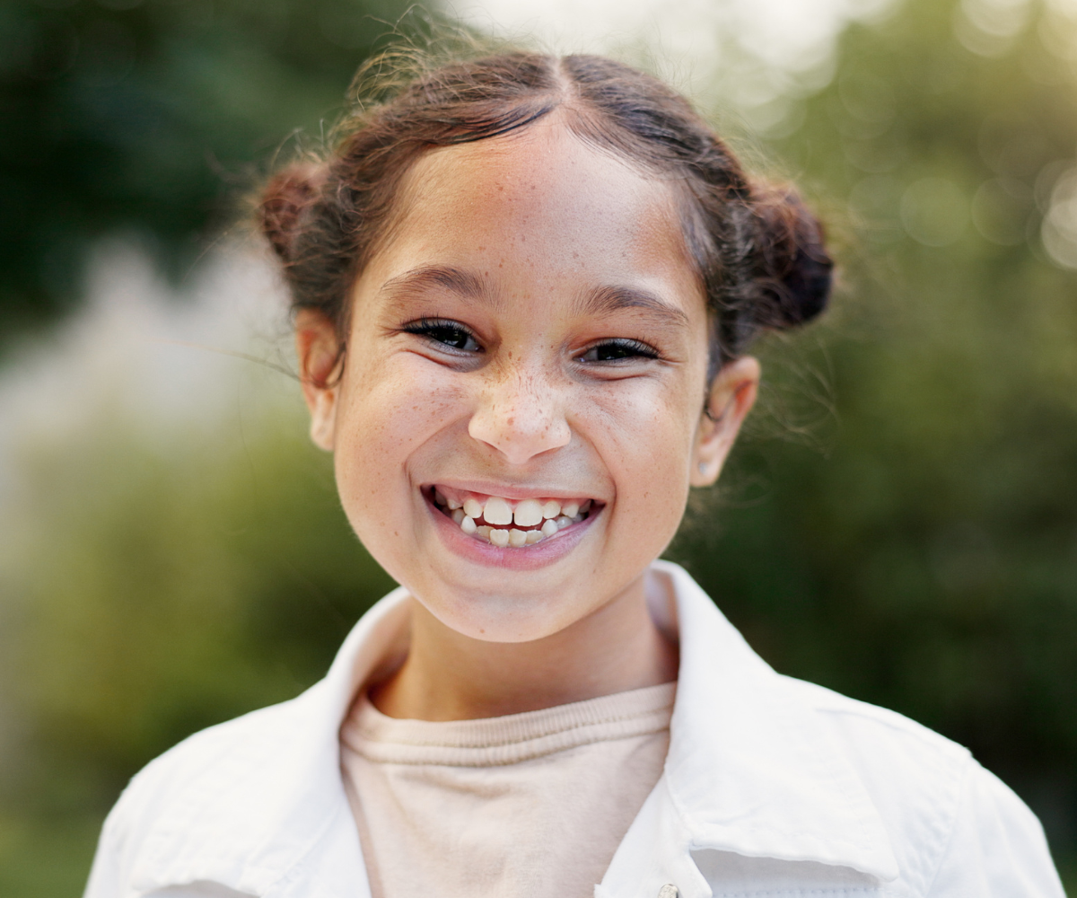 girl smiling in need of a palatal expander for crowded teeth