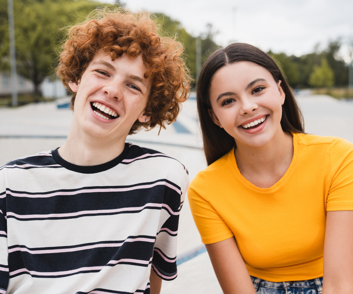 smiling teens with perfect teeth after completing orthodontic treatment and continuing to wear their retainers