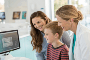an orthodontist showing a family their xray and talking about how long orthodontic treatment takes